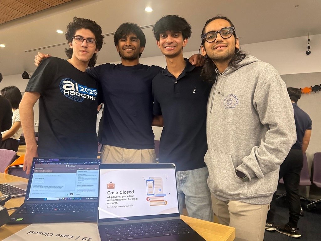 Jason and three teammates behind two laptops showing Case Closed at the Duke AI Hackathon.